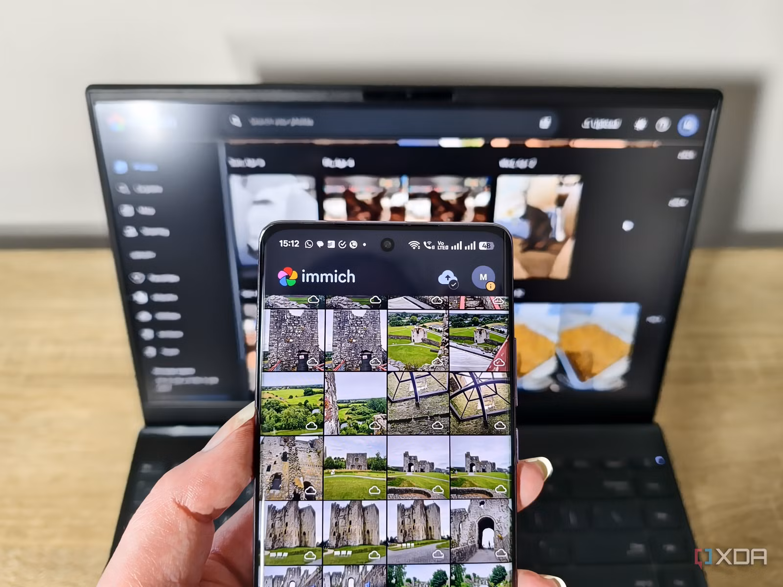 immich-app-on-a-smartphone-with-laptop-in-background